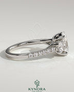 Kynora CJ 2ct oval claw trilogy engagement ring with round side stones, pave band, and trellis gallery design.