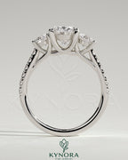 Kynora CJ three stone engagement ring with 2ct oval center, round side stones, pave band, and trellis gallery design.
