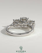 Kynora CJ three-stone engagement ring with 2ct round claw trilogy center, side stones, pave band, and trellis gallery design.