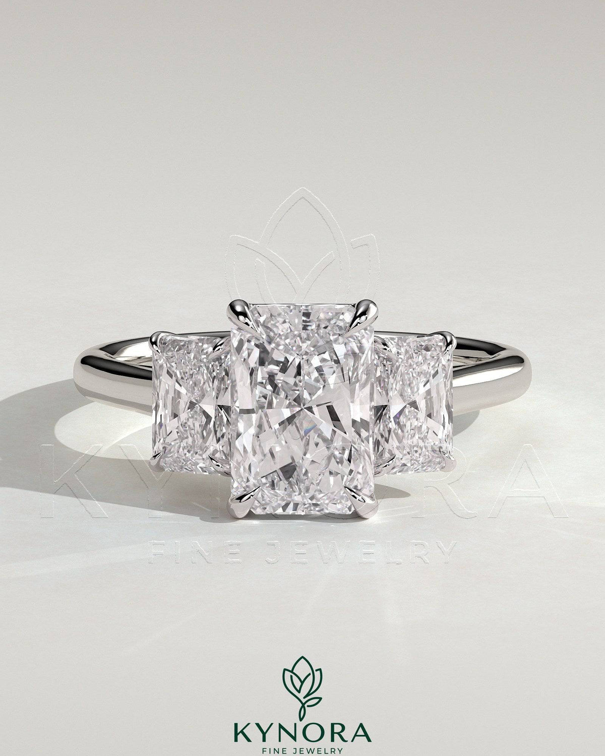 Kynora CJ classic 2ct radiant claw trilogy engagement ring with three sparkling stones and elegant band design.