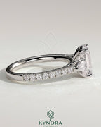 Kynora CJ 2ct emerald claw trilogy engagement ring with pear side stones and pave band, showcasing sparkling diamond accents.