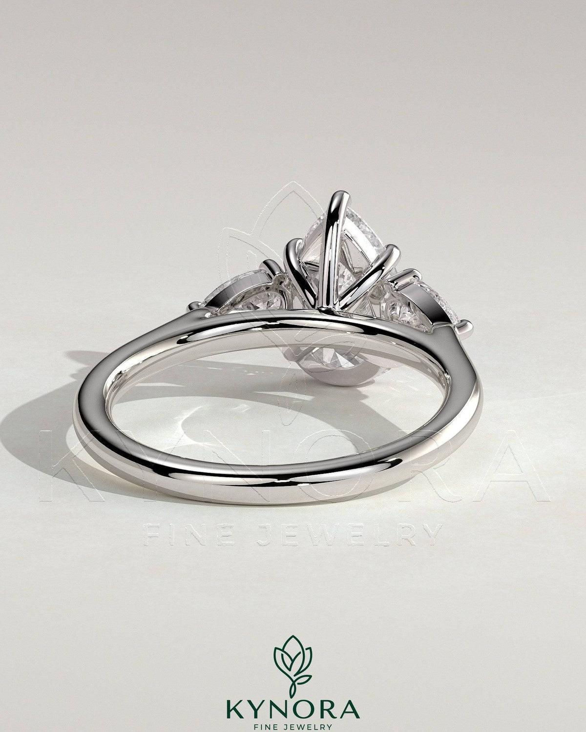 Kynora CJ 2ct pear-shaped diamond trilogy engagement ring with side stones and floating cathedral high setting.