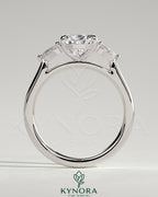 Kynora CJ 2ct pear claw trilogy engagement ring with side stones and floating cathedral high setting, showcasing sparkling diamond design.