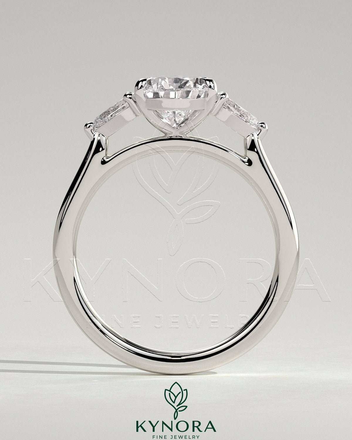 Kynora CJ 2ct pear claw trilogy engagement ring with side stones and floating cathedral high setting, showcasing sparkling diamond design.