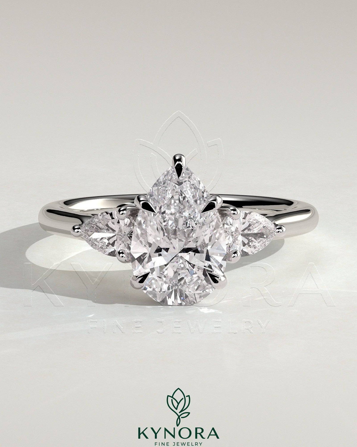 Kynora CJ three-stone engagement ring with 2-carat pear-shaped center diamond, side stones, and floating cathedral setting. Main image
