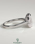 Kynora CJ 3.3ct pear and 3.3ct emerald Toi et Moi engagement ring with bezel and half-bezel setting, detailed gold band design