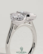 Kynora CJ 3.3ct pear-shaped and 3.3ct emerald-cut Toi et Moi engagement ring featuring bezel and half-bezel settings.