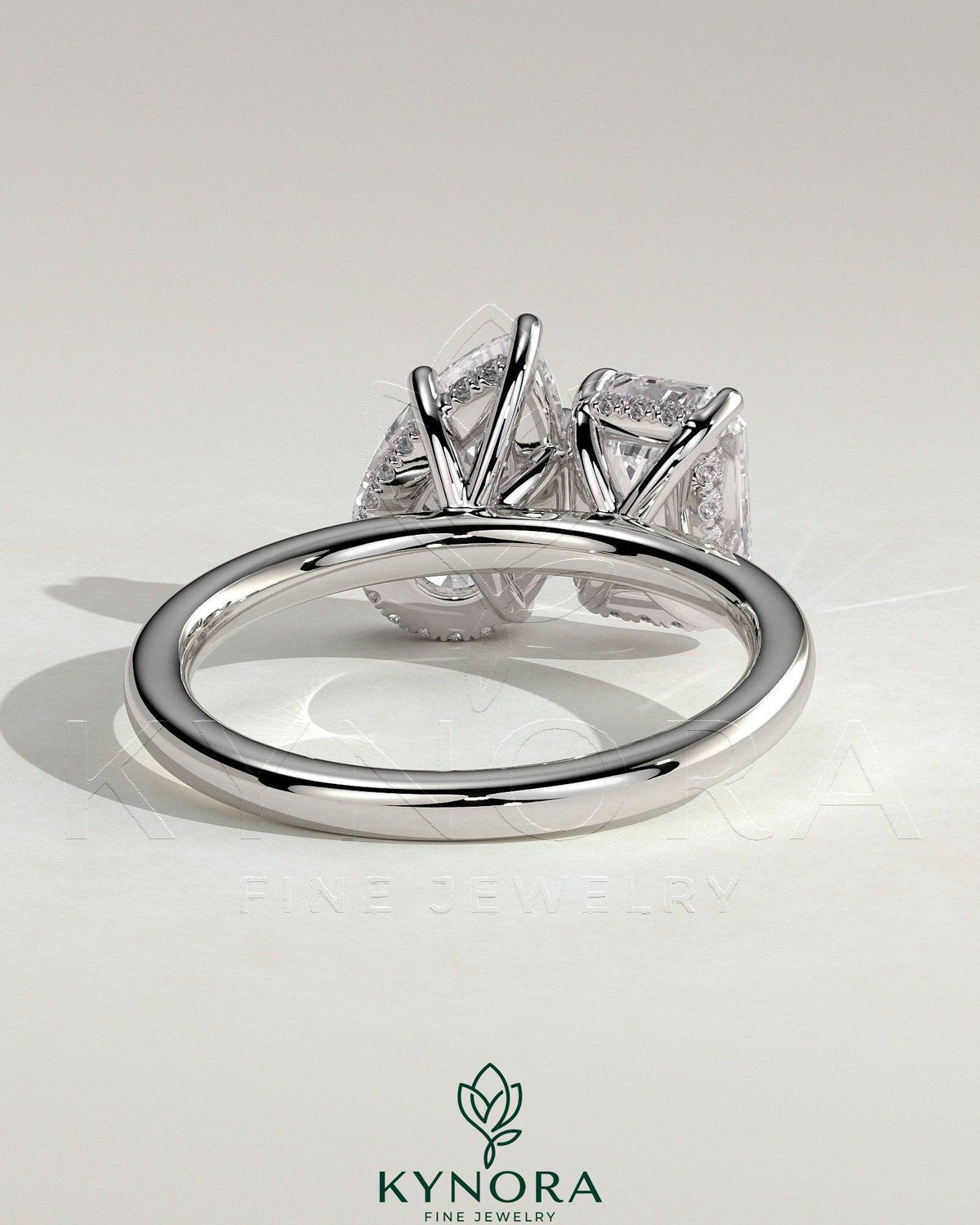 Kynora CJ 1.8ct emerald and 1.5ct pear-shaped diamonds Toi et Moi engagement ring with hidden halo setting.