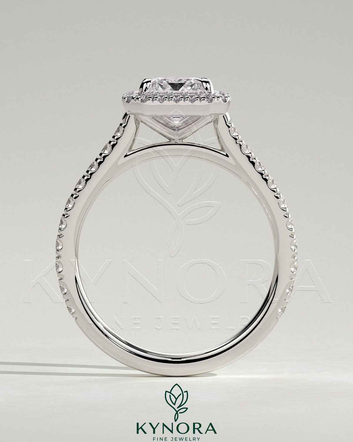 Kynora CJ 2ct emerald claw solitaire engagement ring with halo, pave band, and cathedral high setting.