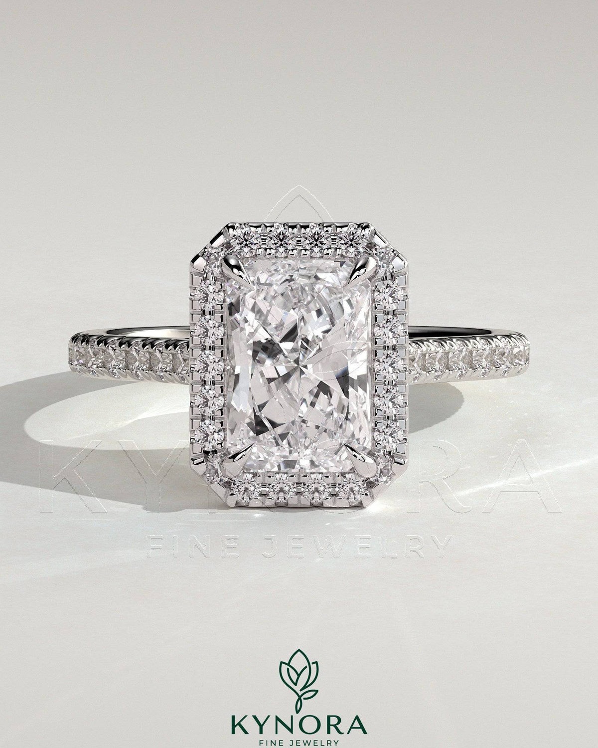 Kynora CJ 2ct radiant claw solitaire engagement ring with halo, pave band, and cathedral high setting showcasing sparkling diamond design. Imagen principal del producto
