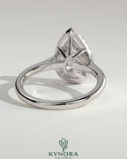 Kynora CJ 2ct pear-shaped diamond solitaire engagement ring with halo and cathedral high setting, showcasing intricate design details.