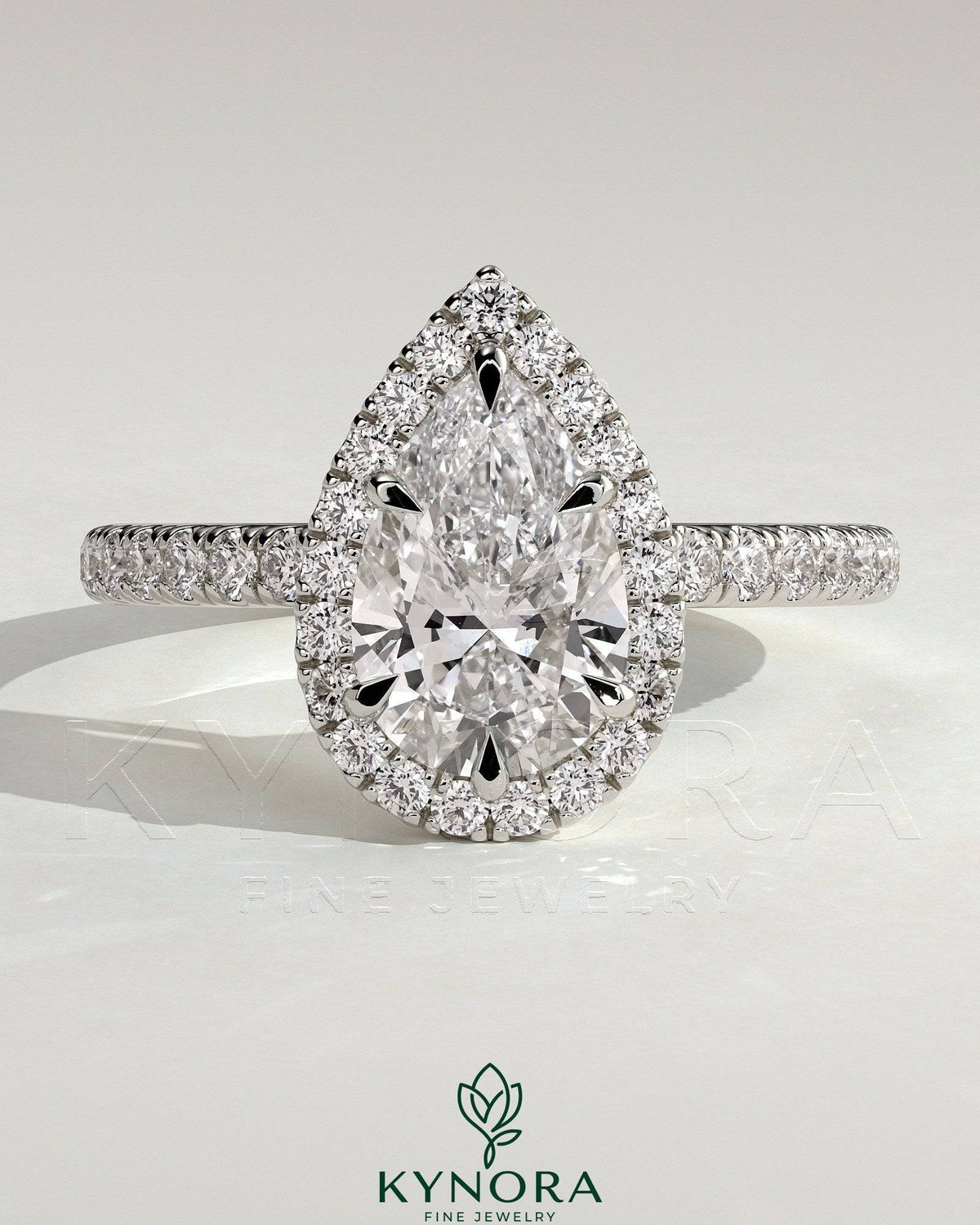 Kynora CJ 2ct pear-shaped diamond solitaire halo engagement ring with pave band and low setting, elegant and sparkling jewelry piece. Imagen principal del producto