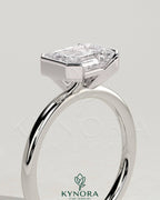 Kynora CJ 2ct emerald cut diamond engagement ring with east-west half bezel setting, showcasing elegant design and sparkling gemstone.
