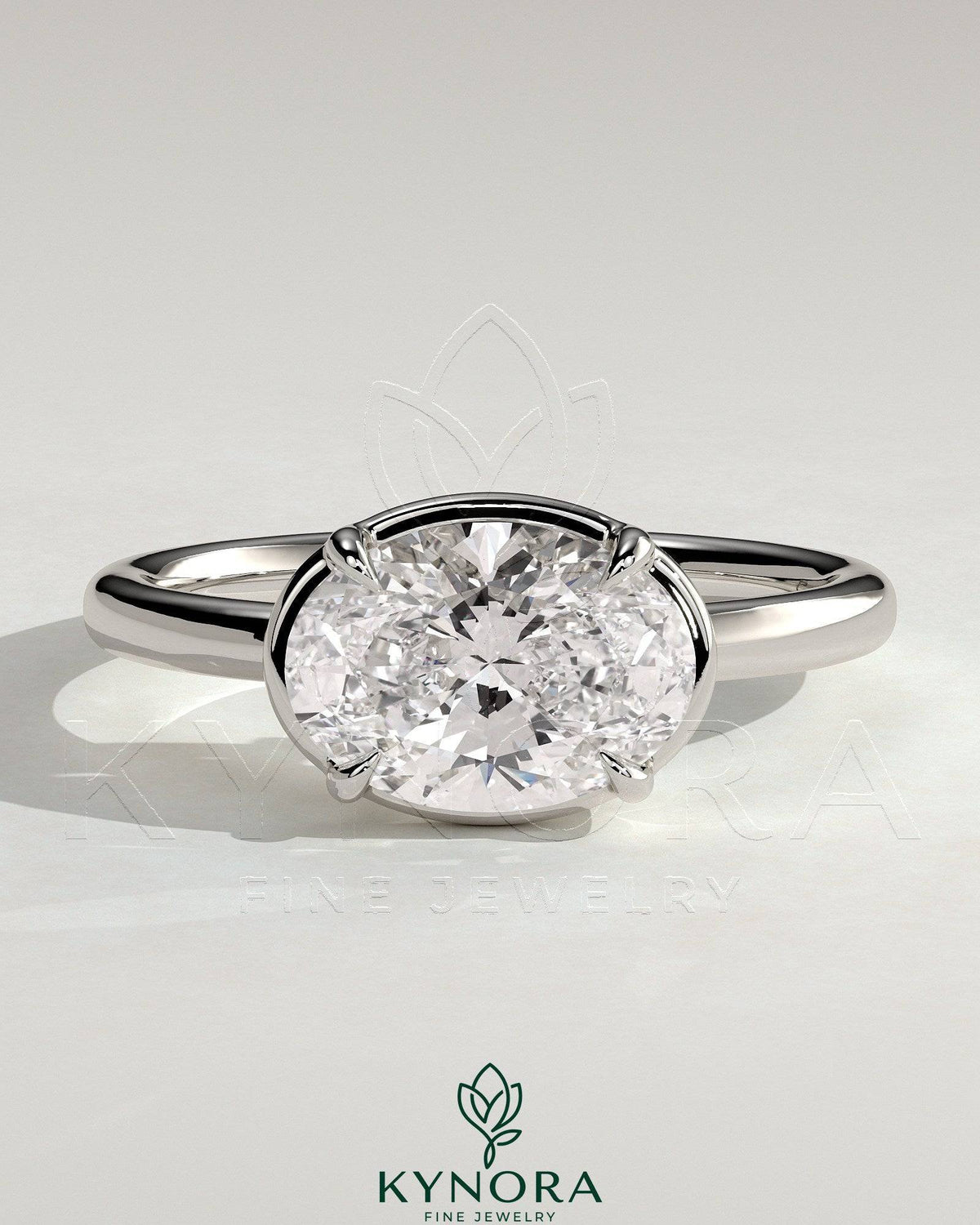 Kynora CJ 2ct oval east-west claw solitaire engagement ring with bezel frame, showcasing a sparkling central diamond on a sleek band. Imagen principal del producto