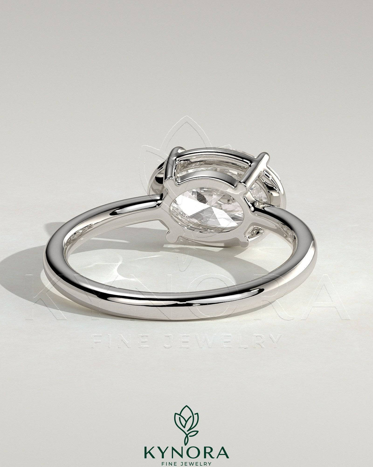 Kynora CJ 2ct oval east-west claw solitaire engagement ring with bezel frame, showcasing a sparkling center stone and elegant design.