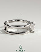 Kynora CJ 2ct emerald east-west claw solitaire engagement ring with a spaced double band design, showcasing a central emerald gemstone.