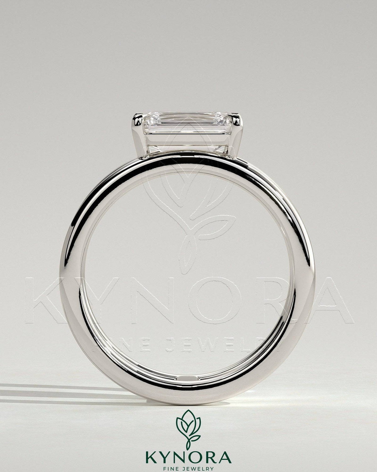 Kynora CJ 2ct emerald east-west claw solitaire engagement ring with a spaced double band design, showcasing a stunning emerald gemstone.