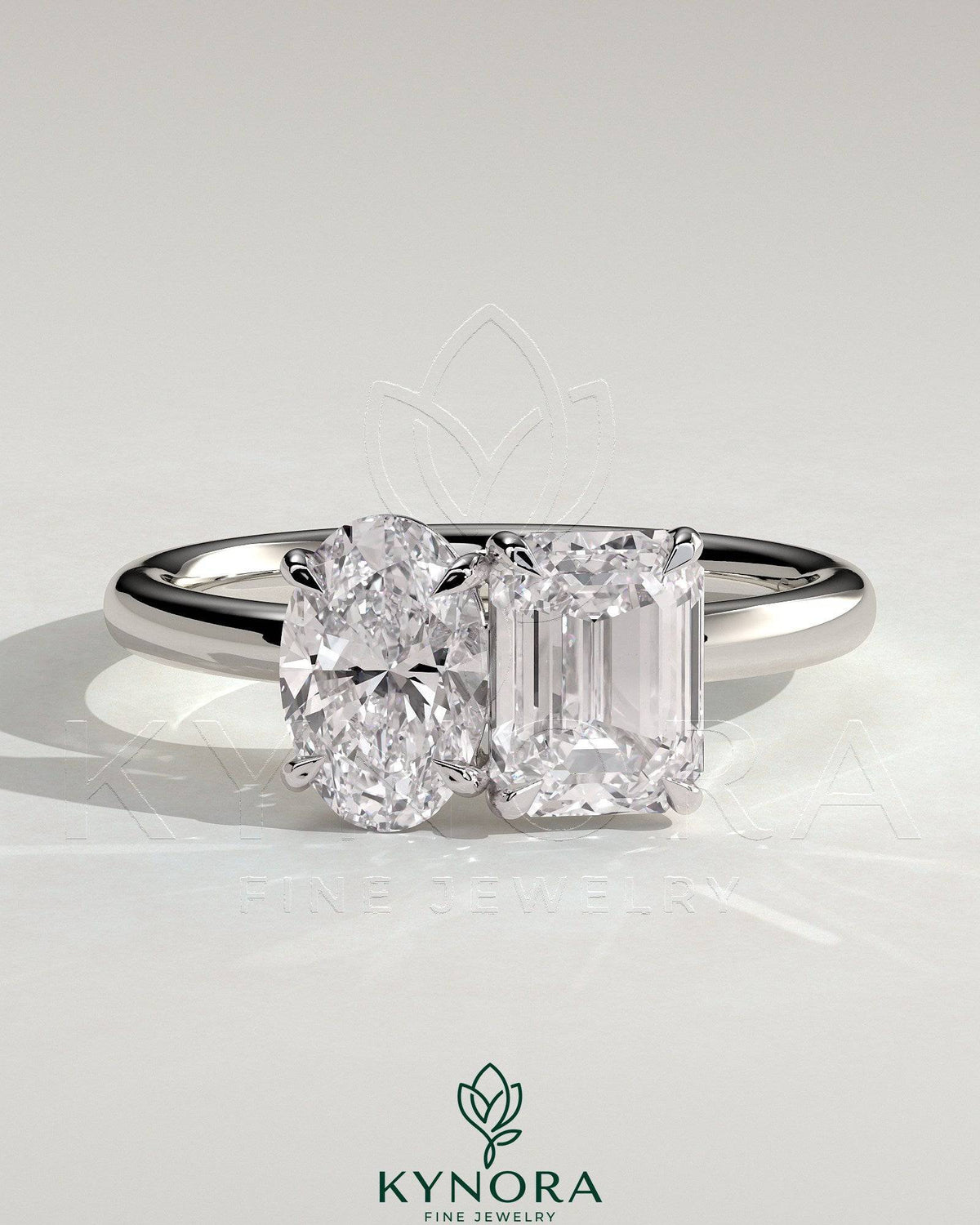 Kynora CJ Toi et Moi engagement ring featuring a 1.05ct oval and 1.8ct emerald-cut diamonds set in a gold band. Imagen principal del producto