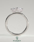 Kynora CJ Toi et Moi engagement ring featuring 1.05ct oval and 1.8ct emerald-cut diamonds with claw settings.