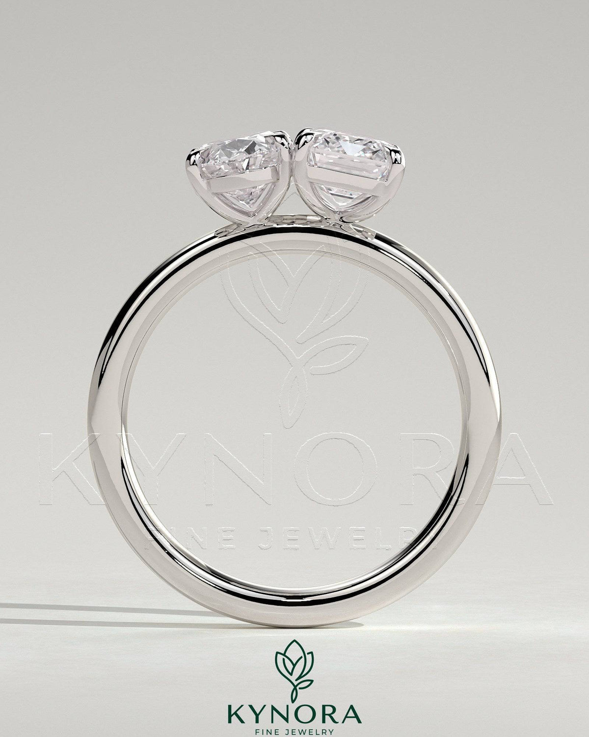 Kynora CJ Toi et Moi engagement ring featuring 1.05ct oval and 1.8ct emerald-cut diamonds with claw settings.