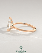 Pear cut moissanite half-bezel engagement ring in 925 silver with botanical ivory background, showcasing elegant jewelry design.