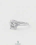 Cushion cut moissanite solitaire engagement ring in sterling silver with a sparkling central stone and silver band.