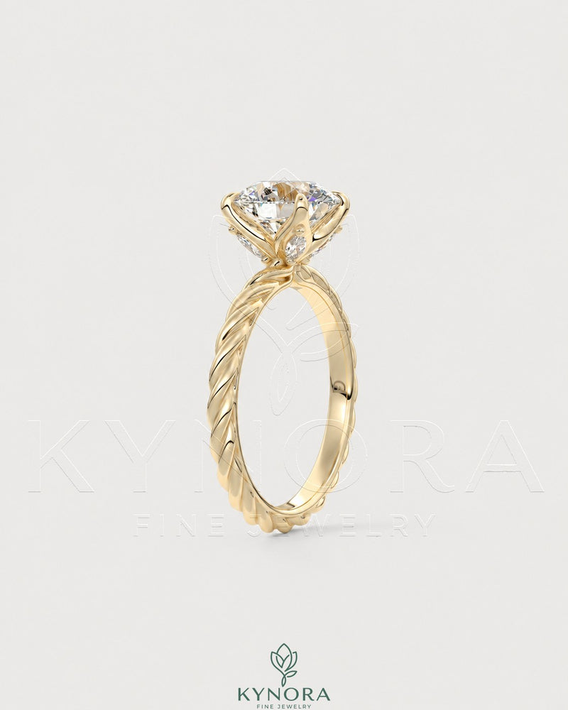 Round moissanite solitaire engagement ring with twisted silver shank by Kynora CJ, showcasing a sparkling center stone and intricate band details.