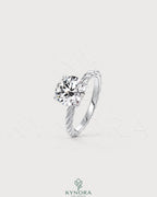 Round moissanite solitaire engagement ring with twisted silver shank by Kynora CJ, featuring a sparkling central stone and intricate band design.