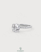 Round moissanite solitaire engagement ring with twisted silver shank by Kynora CJ, showcasing a sparkling center stone and intricate band design.