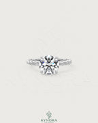 Round moissanite solitaire engagement ring with twisted silver shank by Kynora CJ, featuring a sparkling central stone.