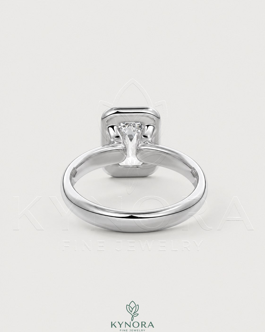 Emerald cut moissanite bezel engagement ring in sterling silver, featuring a sleek design and sparkling center stone.