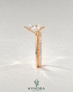 Pear cut moissanite half-bezel engagement ring in 925 silver with intricate band detail on a light ivory background.