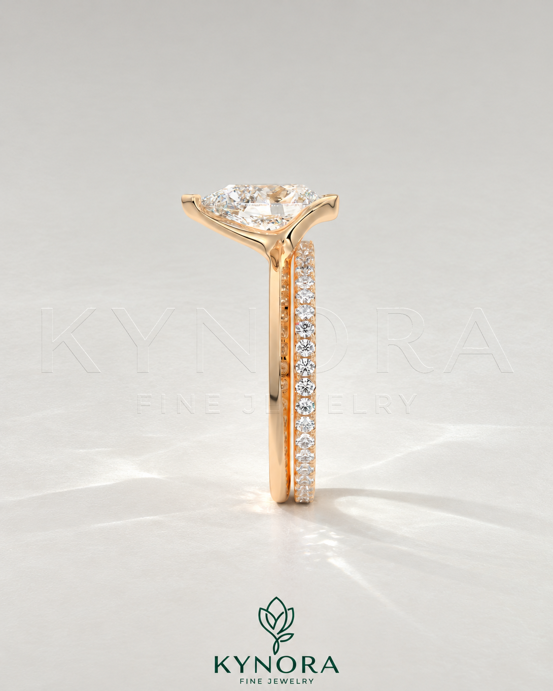 Pear cut moissanite half-bezel engagement ring in 925 silver with intricate band detail on a light ivory background.