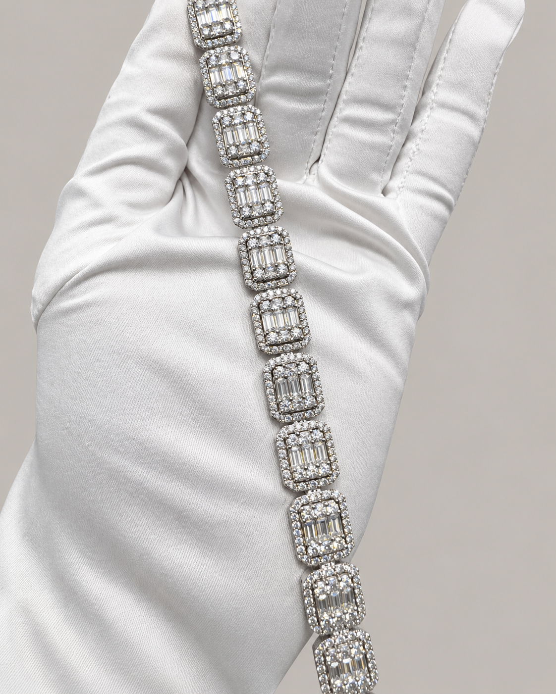 Sterling silver tennis bracelet with baguette stones, stylish hip-hop jewelry by Kynora Jewels on a white glove.