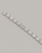 Sterling silver tennis bustdown bracelet by Kynora Jewels, featuring sparkling hip-hop style design, displayed on a white glove.