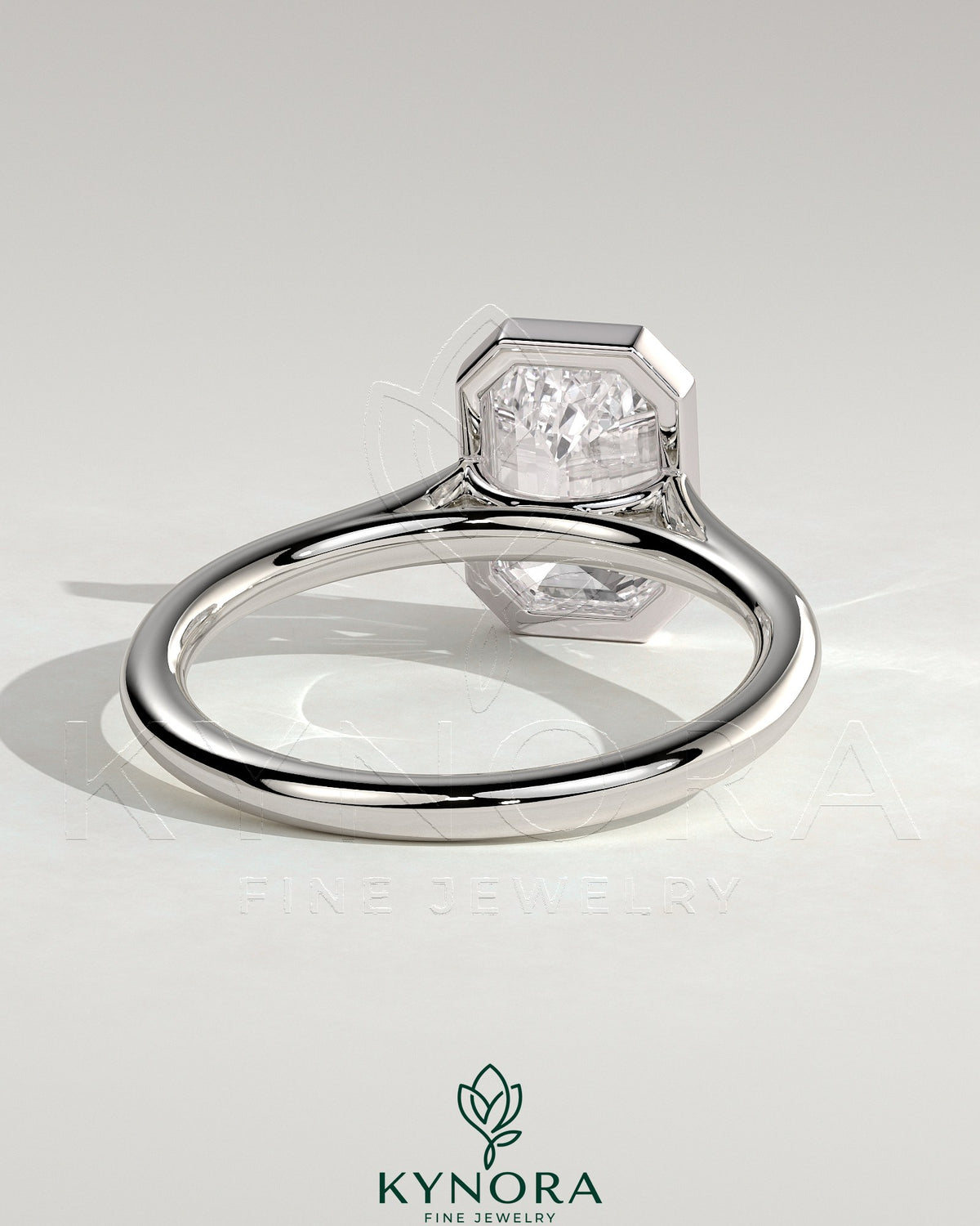 Kynora CJ 2-carat emerald bezel solitaire engagement ring with cathedral high setting, showcasing a sparkling emerald gemstone and elegant design.