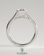 2-carat emerald bezel solitaire engagement ring with cathedral setting by Kynora CJ, featuring a prominent emerald gemstone and elegant band.