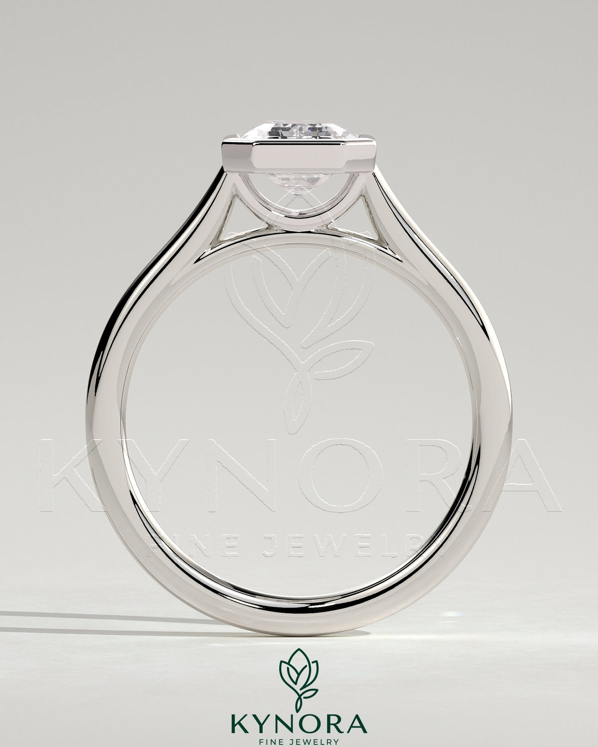 2-carat emerald bezel solitaire engagement ring with cathedral setting by Kynora CJ, featuring a prominent emerald gemstone and elegant band.