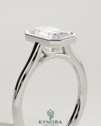 Kynora CJ 2ct emerald bezel solitaire engagement ring with cathedral high setting, showcasing a vibrant emerald gemstone and elegant design.