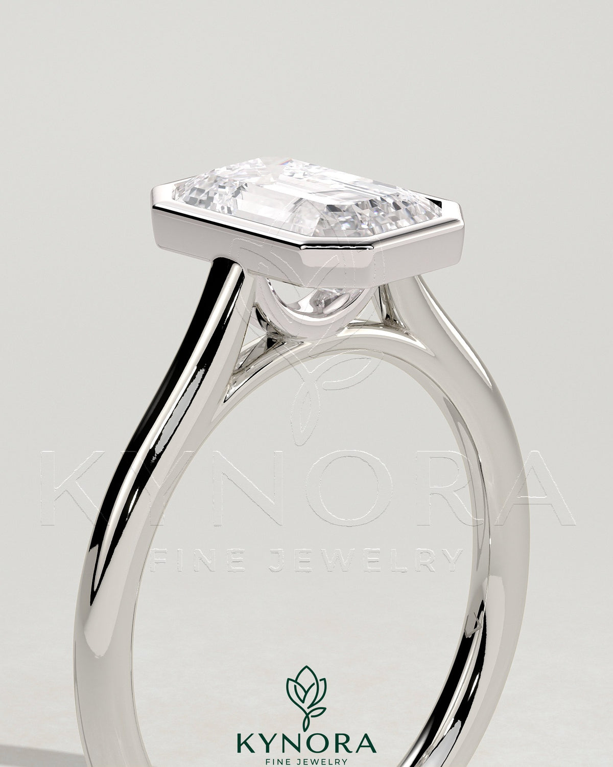 Kynora CJ 2ct emerald bezel solitaire engagement ring with cathedral high setting, showcasing a vibrant emerald gemstone and elegant design.