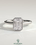 Kynora CJ 2ct emerald bezel solitaire engagement ring with hidden halo and cathedral high setting, showcasing intricate jewelry design.