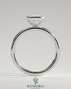 Kynora CJ 2ct emerald bezel solitaire engagement ring with petal gallery design, featuring a central emerald-cut gemstone in a delicate band.