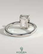 Kynora CJ 2ct emerald claw solitaire engagement ring with bezel setting, featuring a vibrant emerald gemstone and elegant design.