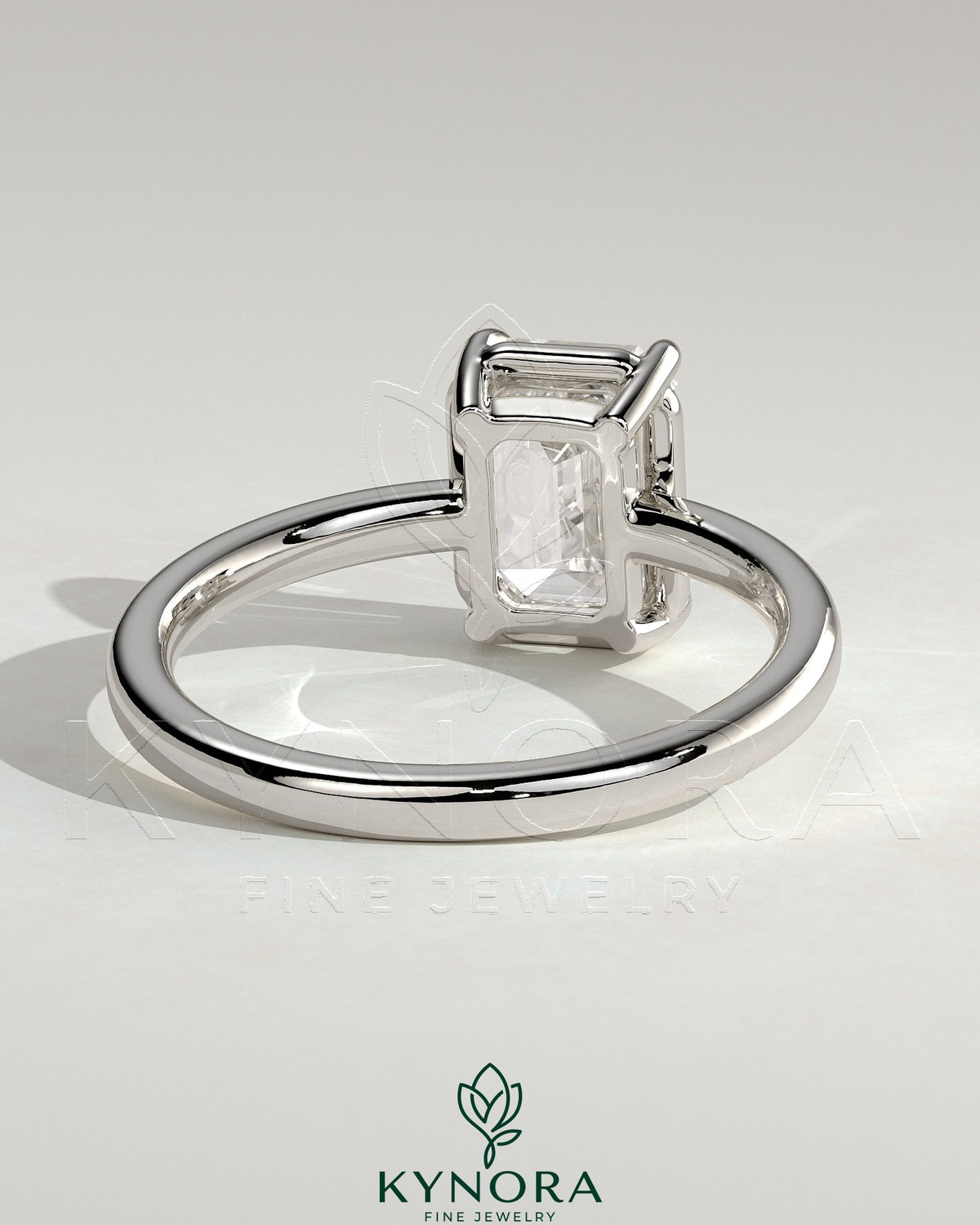 Kynora CJ 2ct emerald claw solitaire engagement ring with bezel setting, featuring a vibrant emerald gemstone and elegant design.
