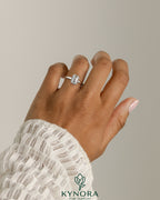Kynora CJ 2ct emerald claw solitaire engagement ring with bezel frame, showcasing a vibrant green emerald gemstone and platinum band.