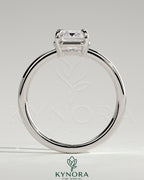 Kynora CJ 2ct emerald claw solitaire engagement ring with bezel frame, featuring a vibrant green emerald gemstone and sleek metal band.