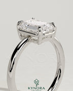 Kynora CJ 2ct emerald claw solitaire engagement ring with bezel frame, showcasing a vibrant green emerald gemstone and elegant metal setting.
