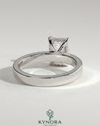 Kynora CJ 2ct emerald bezel engagement ring with flat cigar band and hidden halo, showcasing elegant diamond setting.
