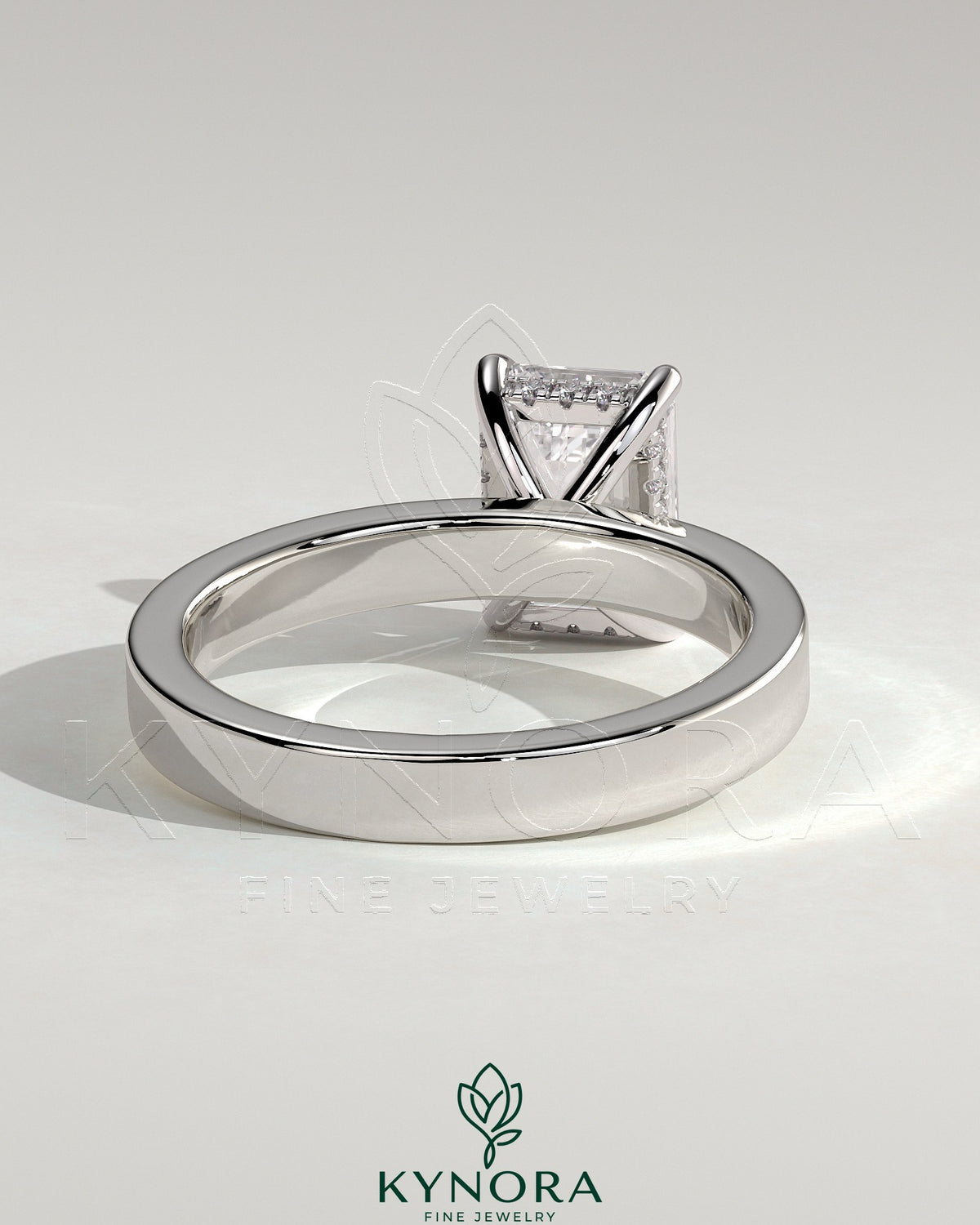Kynora CJ 2ct emerald bezel engagement ring with flat cigar band and hidden halo, showcasing elegant diamond setting.