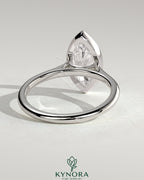 Kynora CJ 2ct marquise bezel solitaire engagement ring with cathedral high setting and intricate metalwork.